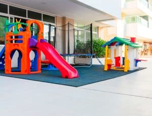 Colorido parque infantil no Paradise Residence com playground e cama elástica.