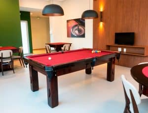 Elegante salão de jogos do Paradise Residence com mesa de bilhar e ambiente acolhedor.