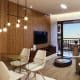 Imagem da sala de estar do PLENO Itaigara, mostrando decoração moderna, amplas janelas e acabamento sofisticado.