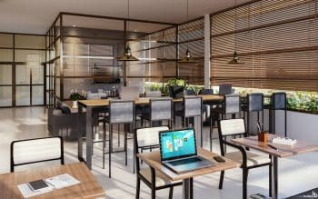 Vista do espaço de coworking moderno e elegante no PLENO Itaigara, com mesas de trabalho, cadeiras confortáveis e iluminação natural.