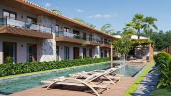 Vista da piscina adulto e infantil com deck de madeira no Villa dos Coqueiros, flanqueada por vegetação tropical e residências.