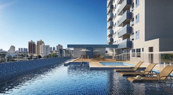 Uma piscina de borda infinita no terraço de um prédio com espreguiçadeiras e vista urbana panorâmica.