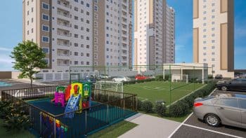 Playground colorido em um condomínio residencial com torres ao fundo e estacionamento adjacente.