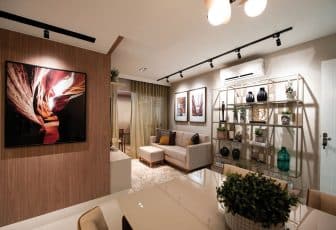 Interior de um living moderno com sofá e chaise, decoração sofisticada, estante decorativa e arte na parede.