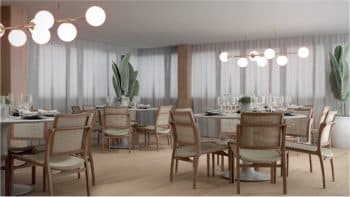 Imagem representando a perspectiva do salão de festas do Jaguaribe OCEAN SIDE, com mesas arrumadas, cadeiras de vime, iluminação suave pendente e plantas decorativas ao fundo.
