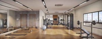 Imagem da academia do empreendimento IBIZA HOME & LIVING em Brotas, Salvador, mostrando equipamentos modernos de musculação e cardio, além de área para exercícios funcionais e vista panorâmica da cidade.