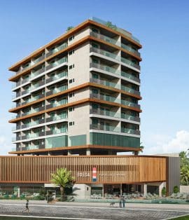 Imagem da fachada do edifício BOSSA Farol de Itapoan, um prédio moderno de múltiplos andares com amplos balcões, acabamentos em madeira e uma área comercial no térreo.