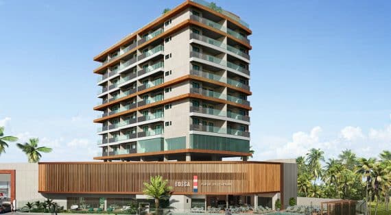 Imagem da fachada do edifício BOSSA Farol de Itapoan, um prédio moderno de múltiplos andares com amplos balcões, acabamentos em madeira e uma área comercial no térreo.