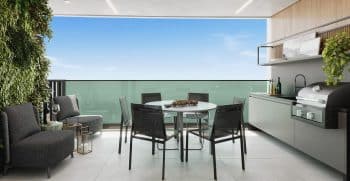 Varanda moderna de um apartamento de alto padrão com área de jantar ao ar livre, churrasqueira integrada e parede de plantas verticais.