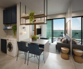 Interior de um apartamento compacto e moderno com cozinha integrada à sala de estar, oferecendo uma vista espetacular do mar através de amplas janelas de vidro.