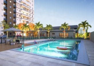 Imagem da piscina adulto e infantil no Jardim Patamares, em Salvador, com cadeiras de descanso, mesas, guarda-sol e vegetação ao redor.