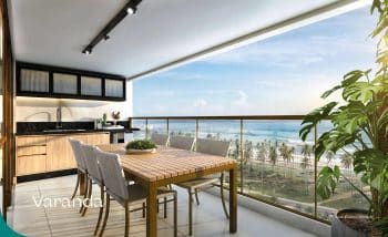 Varanda gourmet com mesa de jantar e vista para o mar no empreendimento Mirari Urban Beach Living.