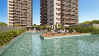 Piscina com borda infinita no MOOD Costa Azul, rodeada por espreguiçadeiras e área de convivência ao ar livre entre as torres do empreendimento.