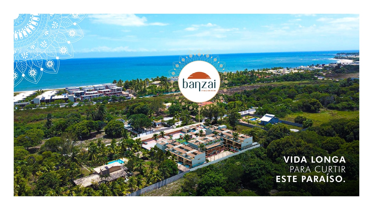 Imagem aérea do condomínio Banzai em Itacimirim, com vista para o mar, rodeado por extensa vegetação e próximo a praias paradisíacas.