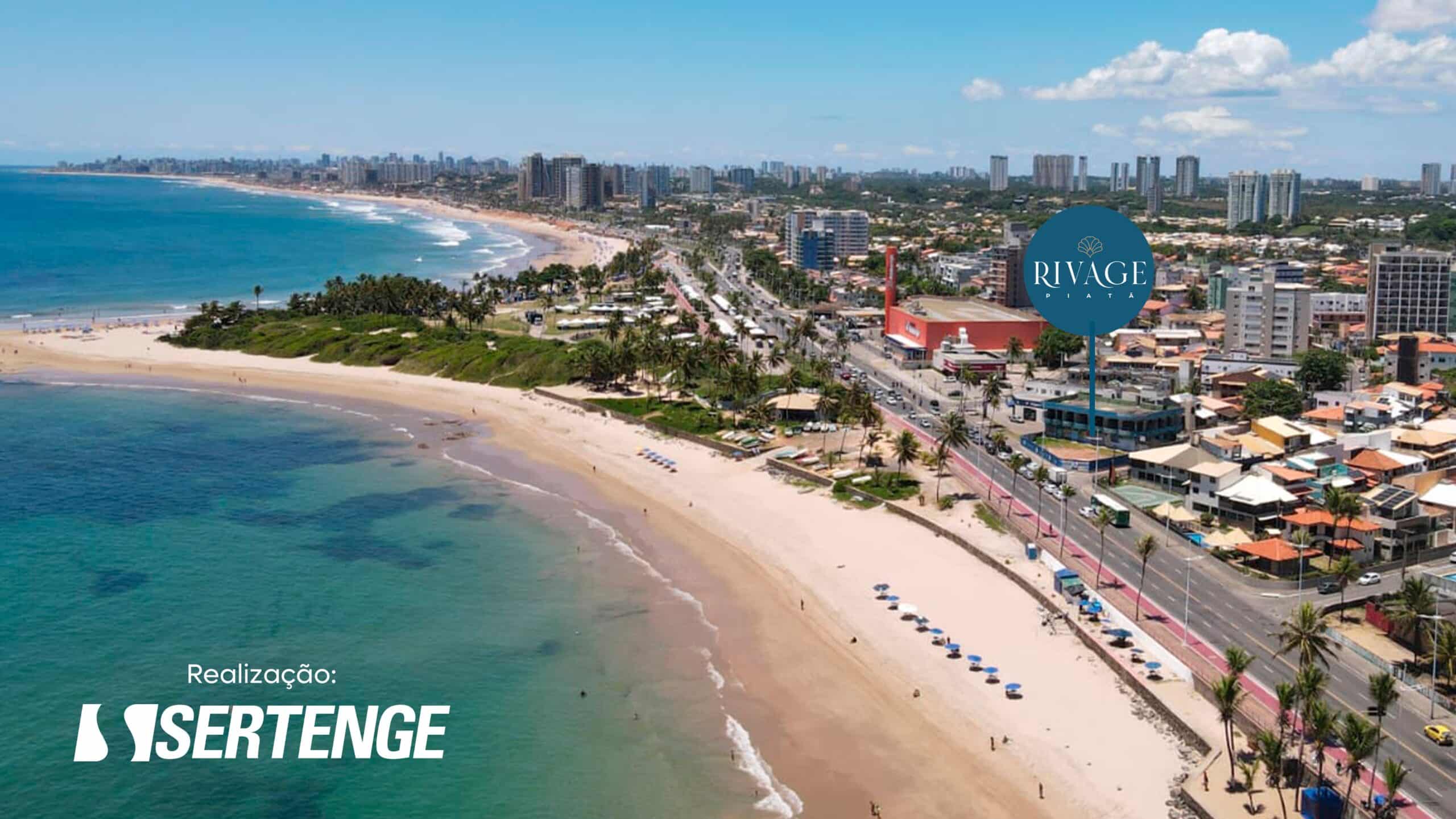 Vista aérea da praia de Piatã, mostrando o empreendimento RIVAGE Piatã próximo à orla, ciclovia e áreas arborizadas, com o mar em destaque.