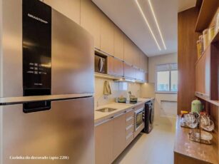 Cozinha moderna com armários planejados, eletrodomésticos em aço inox, iluminação embutida e decoração elegante no Residencial Viena.