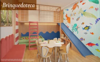 Perspectiva da brinquedoteca do Vog Itapuã, com mesa infantil, piscina de bolinhas, escorregador e decoração colorida com tema marinho.