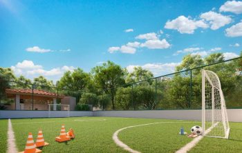Perspectiva do campo gramado do Vivai São Rafael em Salvador, com traves de futebol, grama sintética e área de lazer esportiva ao ar livre.