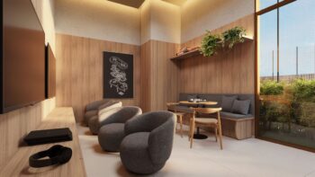 Sala de jogos do Elleve Horto com TVs, poltronas, mesa para jogos de tabuleiro e decoração moderna em tons amadeirados