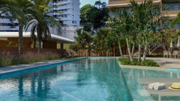 Piscina com raia do Elleve Horto cercada por palmeiras, espreguiçadeiras, área gourmet e vegetação tropical em ambiente sofisticado