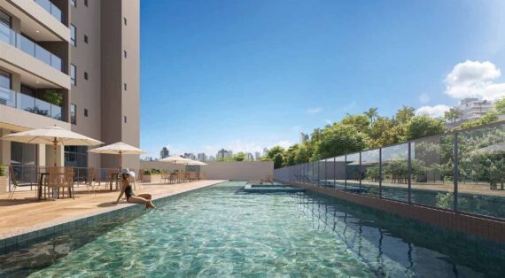 Piscina adulto com deck e espreguiçadeiras no Sevilha Residencial, cercada por vegetação e vista urbana