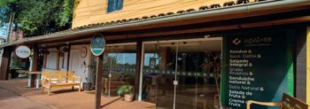 Fachada de lojas em Itacimirim com destaque para o Açaí 55 e o Crema Café, estabelecimentos próximos ao ZN Itacim com opções saudáveis e ambiente acolhedor.