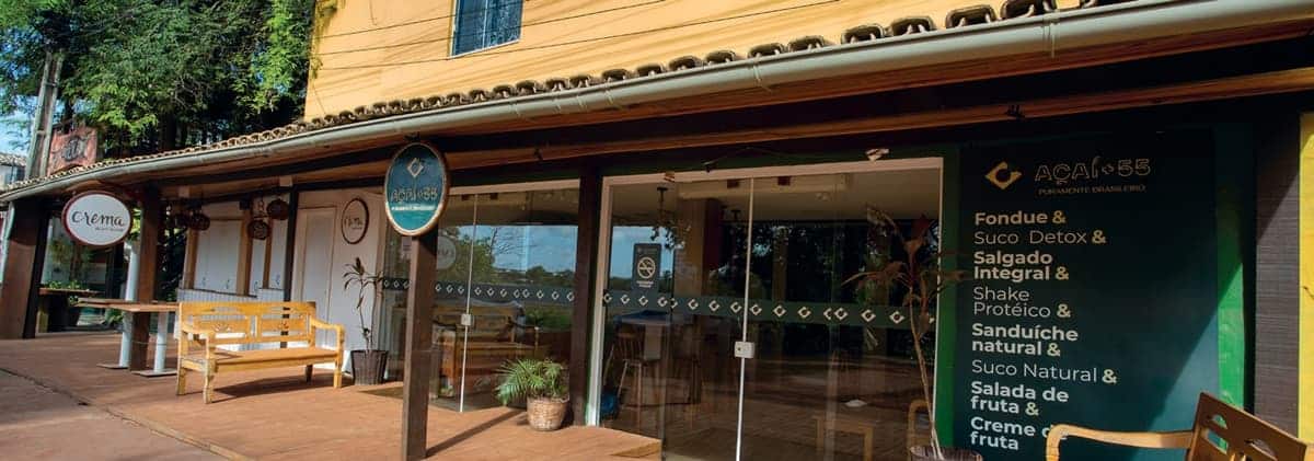 Fachada de lojas em Itacimirim com destaque para o Açaí 55 e o Crema Café, estabelecimentos próximos ao ZN Itacim com opções saudáveis e ambiente acolhedor.