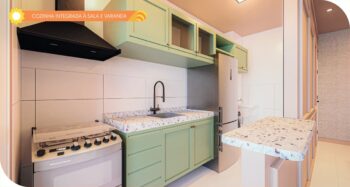 Cozinha planejada do Solare Residence com armários verdes, bancada em granito, fogão, coifa e integração com a sala e varanda.