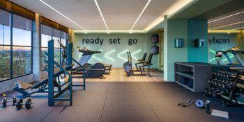 Academia do Residencial Ilha de Maui com equipamentos modernos, vista panorâmica e ambientação motivadora com a frase “ready set go”.