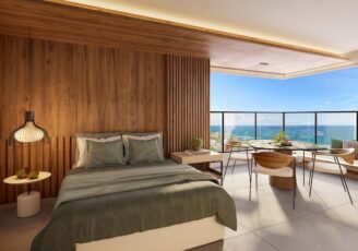 Studio mobiliado do Residencial Ilha de Maui com cama de casal, mesa de jantar e varanda envidraçada com vista para o mar.