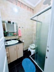 Banheiro do apartamento usado 3 quartos no Garcia, em Salvador, com box de vidro, pia com gabinete e revestimento em cerâmica.