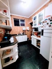 Cozinha do apartamento usado 3 quartos no Garcia, Salvador, com armários planejados, bancada em granito, piso em mármore e iluminação natural.