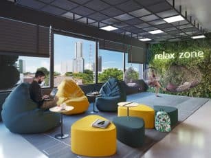 Espaço Relax Zone do Easy São Lázaro em Salvador, com pufes coloridos, cadeiras suspensas, parede verde e vista para a cidade.