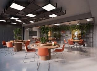 Espaço de coworking do Easy São Lázaro em Salvador, com mesas redondas, cadeiras confortáveis, plantas decorativas e ambiente integrado.