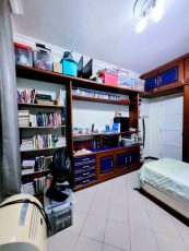Quarto do apartamento usado 3 quartos no Garcia, em Salvador, com cama, estante de livros, armários planejados em madeira e prateleiras.