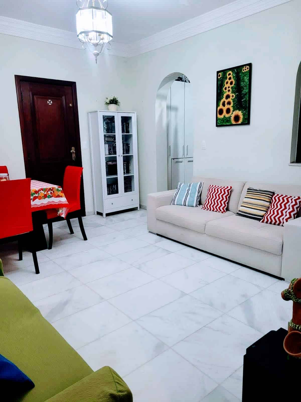 Sala do apartamento usado 3 quartos no Garcia, em Salvador, com sofás, mesa de jantar, piso em mármore claro e decoração aconchegante.