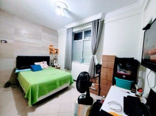 Suíte do apartamento usado 3 quartos no Garcia, em Salvador, com cama de casal, cortinas, mesa de trabalho e TV fixada na parede.