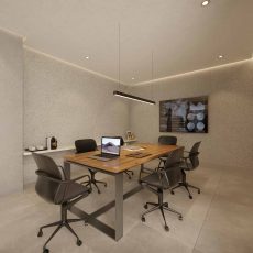 Sala de trabalho do coworking do Residencial Florença com mesa de reunião em madeira, cadeiras ergonômicas e iluminação moderna.