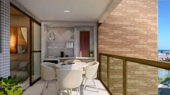 Varanda da planta tipo 01 do Laut Jaguaribe, com mesa redonda, cadeiras estofadas, decoração moderna e vista lateral para o mar de Jaguaribe.