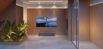 Clausura do Lumio Jardim Apipema em Salvador, com design moderno em madeira ripada, iluminação embutida e área verde decorativa.