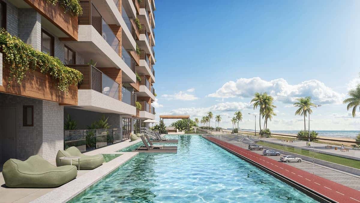 Piscina do Gal Urban Beach Living com vista para a orla, espreguiçadeiras na água e área de convivência em frente à praia