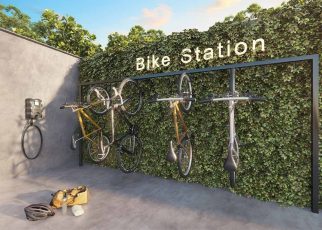 Bicicletário do Lumio Jardim Apipema em Salvador, com suporte vertical para bikes, parede verde e estação de manutenção.