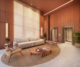 Lobby social com pé-direito duplo do Lumio Jardim Apipema em Salvador, com sofá, poltronas de design e acabamento em madeira natural.