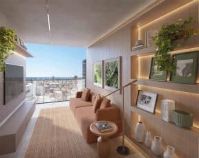 Living integrado à varanda do Lumio Jardim Apipema em Salvador, com sofá aconchegante, prateleiras decoradas e vista panorâmica para o mar.