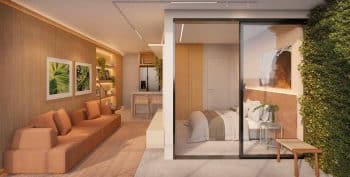 Apartamento quarto e sala do Lumio Jardim Apipema em Salvador, com living integrado à varanda, cozinha compacta e design contemporâneo.