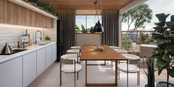 Espaço gourmet do Vivid Pituba com mesa de jantar, bancada em mármore e integração com área externa