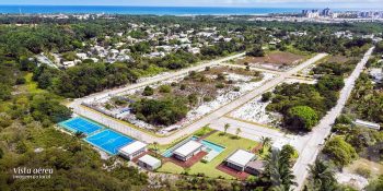Vista aérea do Reserva Byom em Busca Vida mostrando lotes, quadra poliesportiva, piscina e áreas verdes próximas ao litoral.