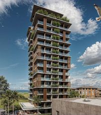 Torre residencial do Yu Corsário Smart Hub com varandas, vegetação integrada e vista para a nova orla da Pituba, em Salvador.