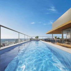 Piscina no rooftop do COLLECTION Barra com deck molhado e vista panorâmica para o mar da Barra, em Salvador, integrada às áreas de lazer do empreendimento.