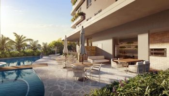 Área de piscina com espreguiçadeiras, mesas externas e espaço gourmet integrado ao condomínio.